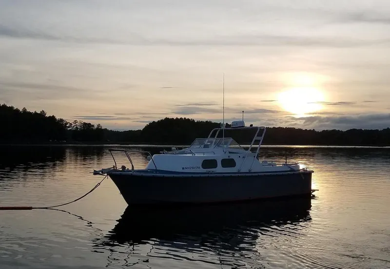 Slide: The Image of 26-Foot MTI US NAVY Personnel Boat, 1990 model, anchored at sunset on a calm lake. - 2
