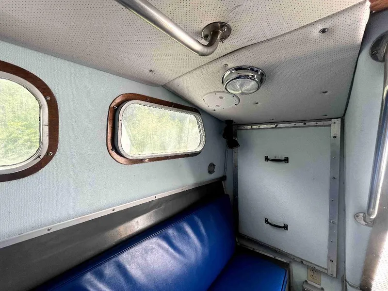 Slide: The Image of Interior of 1990 MTI 26-Foot US NAVY Personnel Boat with blue seating and porthole windows. - 30