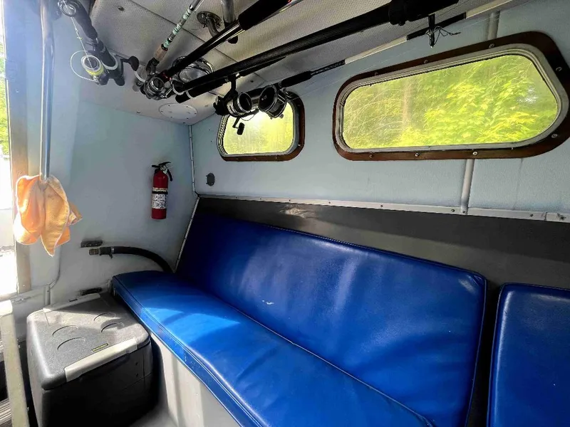 Slide: The Image of Interior of a 1990 MTI 26-Foot US NAVY Personnel Boat with blue seating and fishing rods. - 31