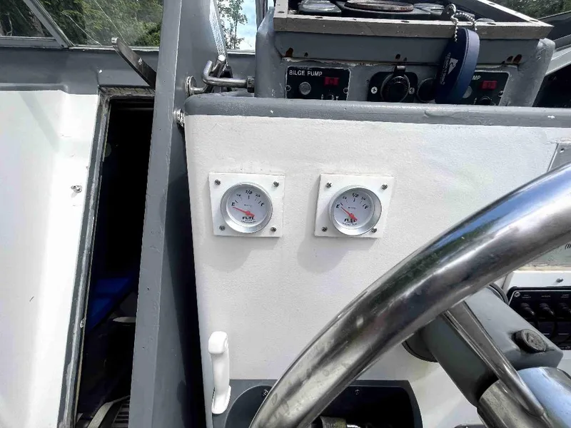 Slide: The Image of Control panel of a 1990 MTI 26-Foot US Navy Personnel Boat with gauges and steering wheel. - 34