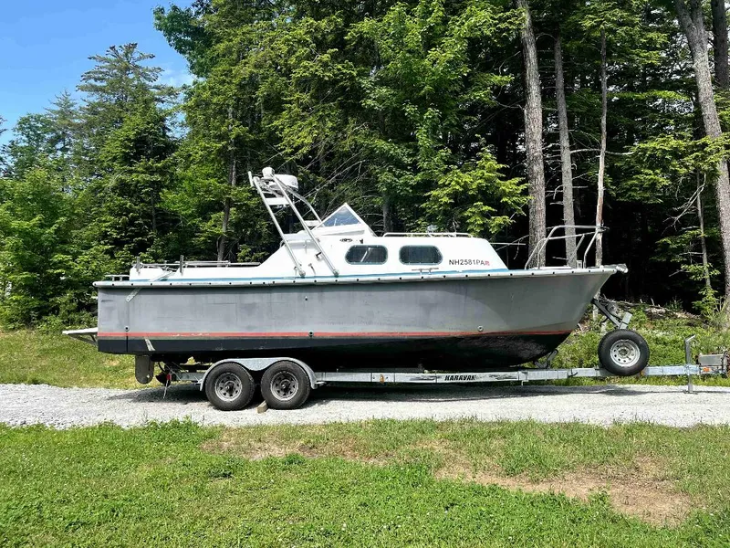 Slide: The Image of 1990 MTI 26-Foot US NAVY Personnel Boat on trailer in a wooded area. - 6