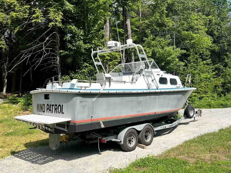Slide: The Image of 1990 MTI 26-Foot US NAVY Personnel Boat on trailer in wooded area. - 7