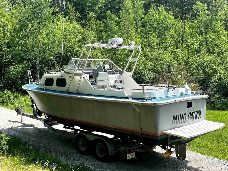 Slide: The Image of 1990 MTI 26-Foot US NAVY Personnel Boat on trailer in a wooded area. - 9