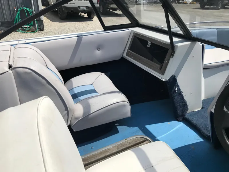 Slide: The Image of Interior of a 1990 Sea Sprite 155BR boat with white and blue seating. - 12