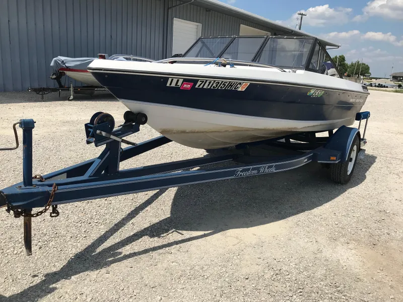 Slide: The Image of 1990 Sea Sprite 155BR boat on a trailer in a gravel lot. - 3