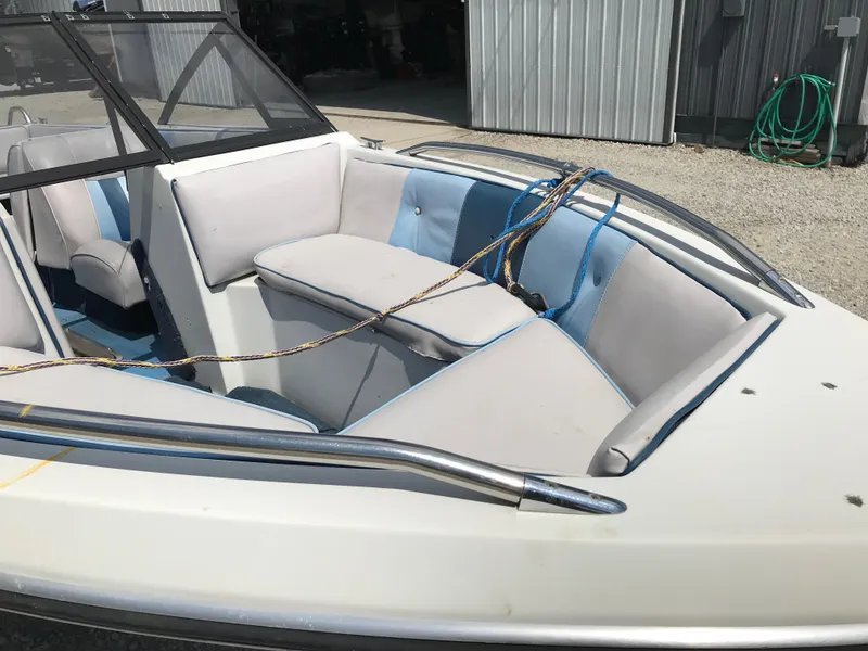 Slide: The Image of 1990 Sea Sprite 155BR boat with blue and white interior, docked near a metal shed. - 8