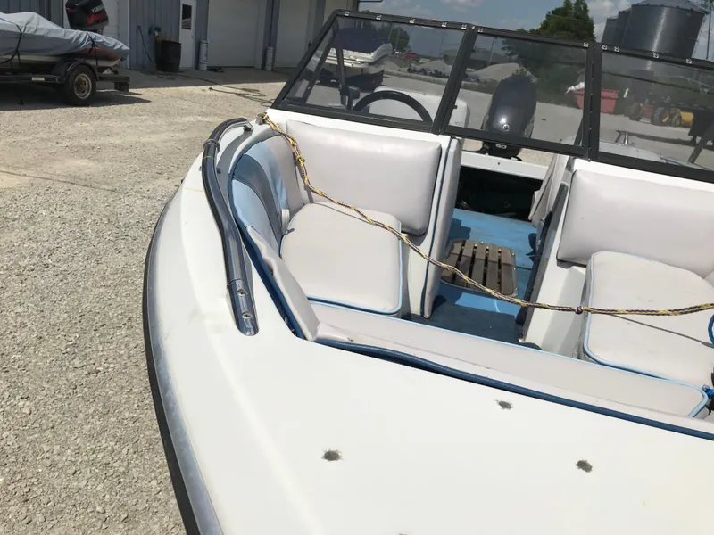 Slide: The Image of 1990 Sea Sprite 155BR boat with white and blue interior, docked outdoors. - 9