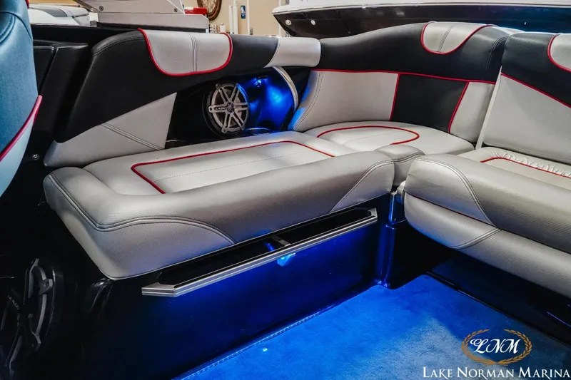 Slide: The Image of 2014 MasterCraft XStar interior with gray and black leather seats, red accents, and blue LED lighting. - 17