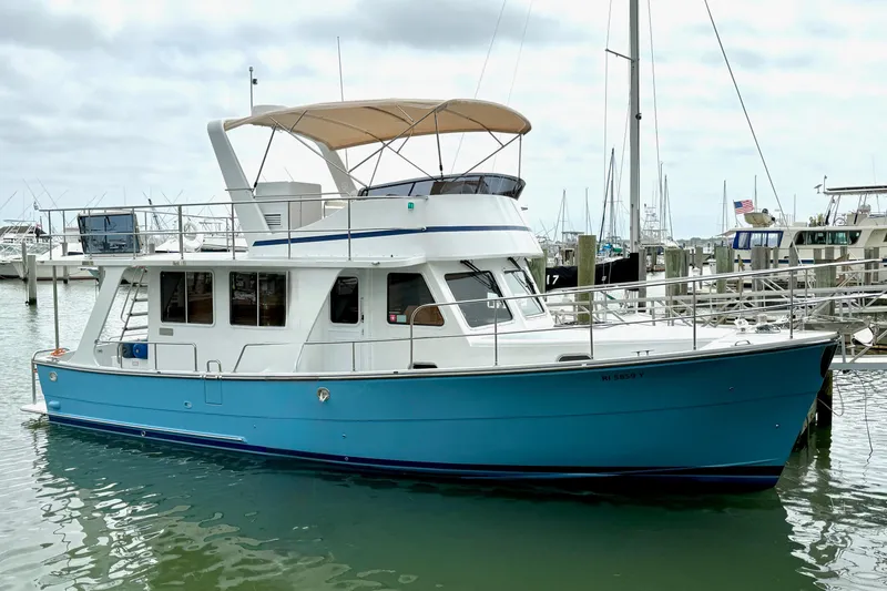 The Image of 2024 Helmsman Trawlers Helmsman 38 Sedan, blue hull, docked in marina. - 0
