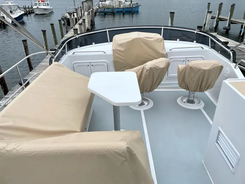 Slide: The Image of Helmsman Trawlers 38 Sedan 2024, covered deck with seating area. - 18