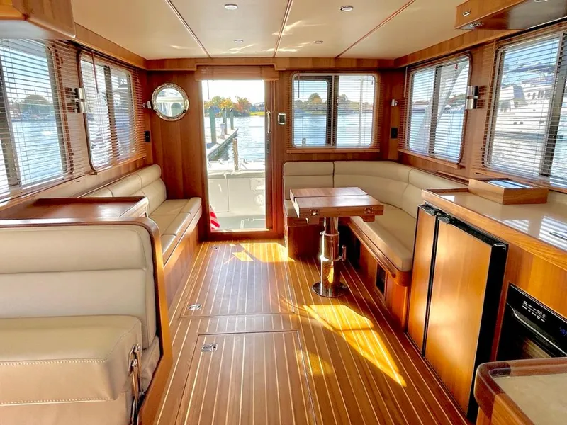Slide: The Image of Interior of 2024 Helmsman 38 Sedan with wood flooring and seating area. - 2