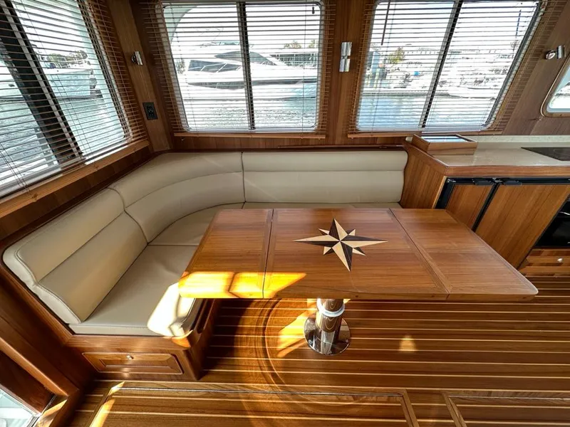 Slide: The Image of Interior of 2024 Helmsman 38 Sedan with wooden table and seating. - 4