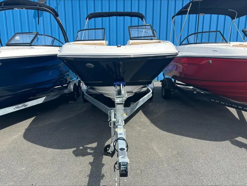 Slide: The Image of 2024 Bayliner VR6 boat on a trailer, flanked by two other boats. - 2