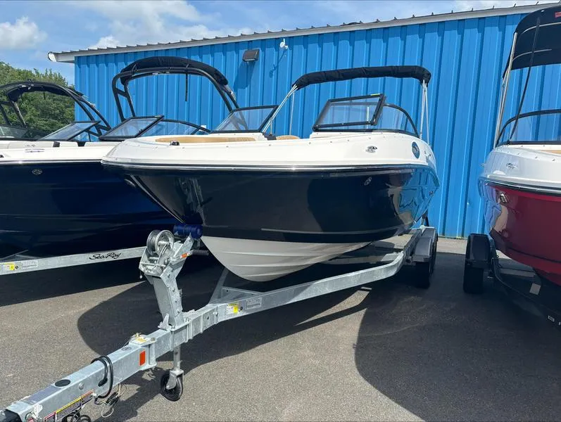 Slide: The Image of 2024 Bayliner VR6 boat on a trailer, parked outdoors near a blue building. - 3