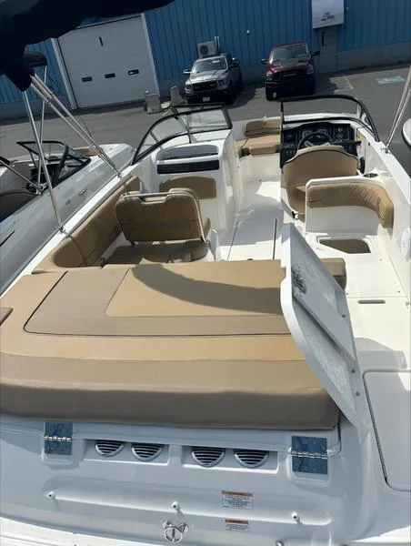 Slide: The Image of 2024 Bayliner VR6 boat with beige seating and spacious deck. - 8
