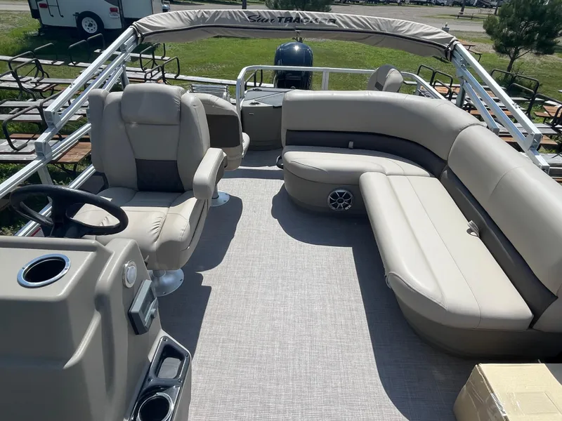 Slide: The Image of 2024 Sun Tracker Bass Buggy 18 DLX pontoon boat interior with beige seating and steering console. - 12