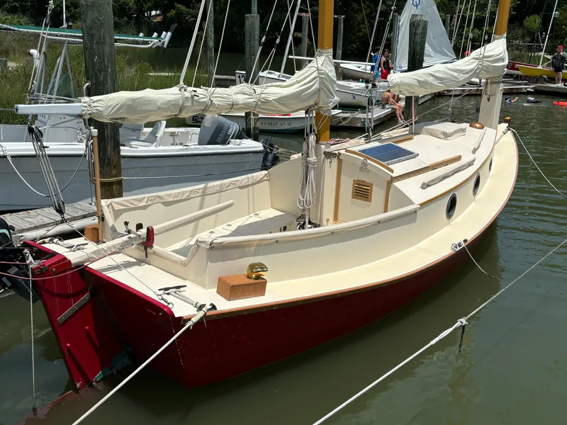 The Image of Custom 2011 Cat Ketch sailboat docked, featuring red hull and cream deck. - 0