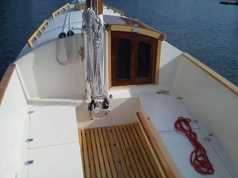 Slide: The Image of Custom Cat Ketch 2011 sailboat with wooden deck and ropes, docked on calm water. - 5
