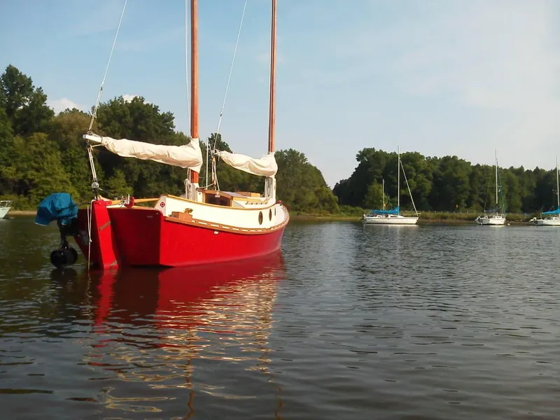 Slide: The Image of Red 2011 Custom Cat Ketch sailboat anchored on a calm lake with other boats. - 7
