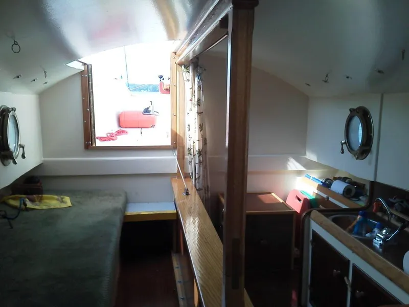 Slide: The Image of Interior of a 2011 Custom Cat Ketch sailboat with portholes and compact living space. - 8