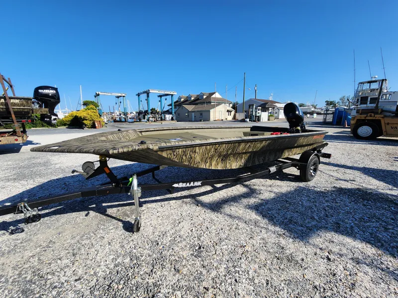 The Image of 2024 SeaArk 1960 Slayer Pro boat on a trailer in a marina. - 1