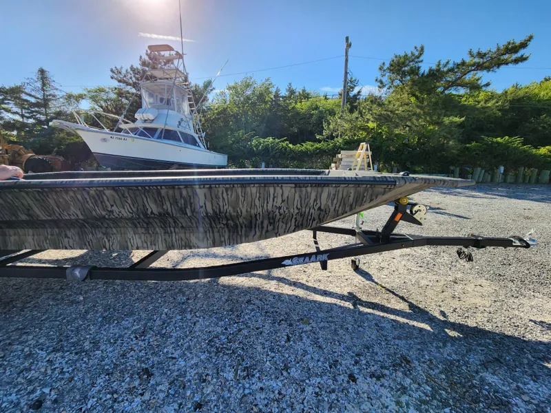 Slide: The Image of 2024 SeaArk 1960 Slayer Pro boat on trailer in a sunny outdoor setting. - 9