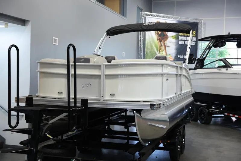 Slide: The Image of 2024 Barletta ARIA A20UC pontoon boat displayed indoors on a trailer. - 14