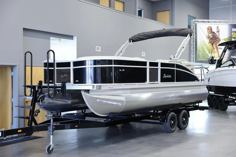 Slide: The Image of 2024 Barletta Aria A22CC pontoon boat on trailer in showroom. - 2