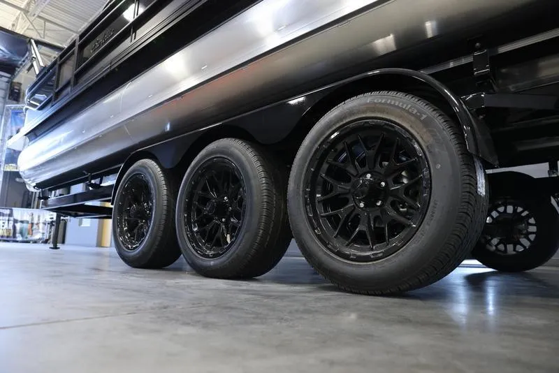 Slide: The Image of 2024 Barletta CORSA 25UE pontoon boat on a triple-axle trailer. - 6