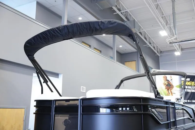 Slide: The Image of 2024 Barletta CORSA 25UE pontoon boat with black canopy in showroom. - 8