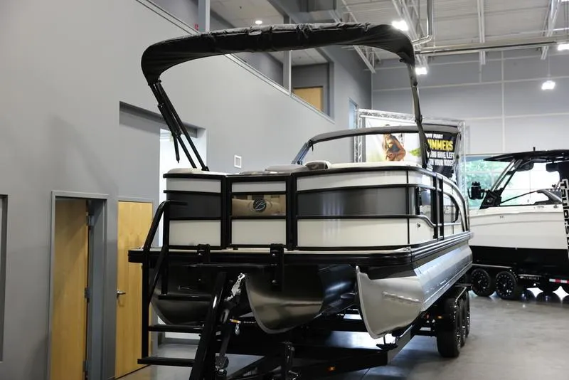 Slide: The Image of 2024 Barletta LUSSO L25M pontoon boat displayed indoors on a trailer. - 13