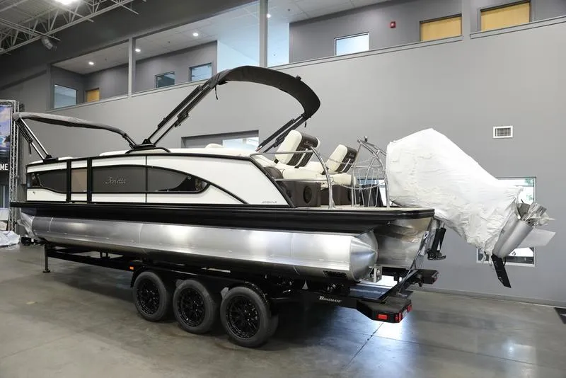 Slide: The Image of 2024 Barletta LUSSO L25M pontoon boat on a triple-axle trailer in a showroom. - 3