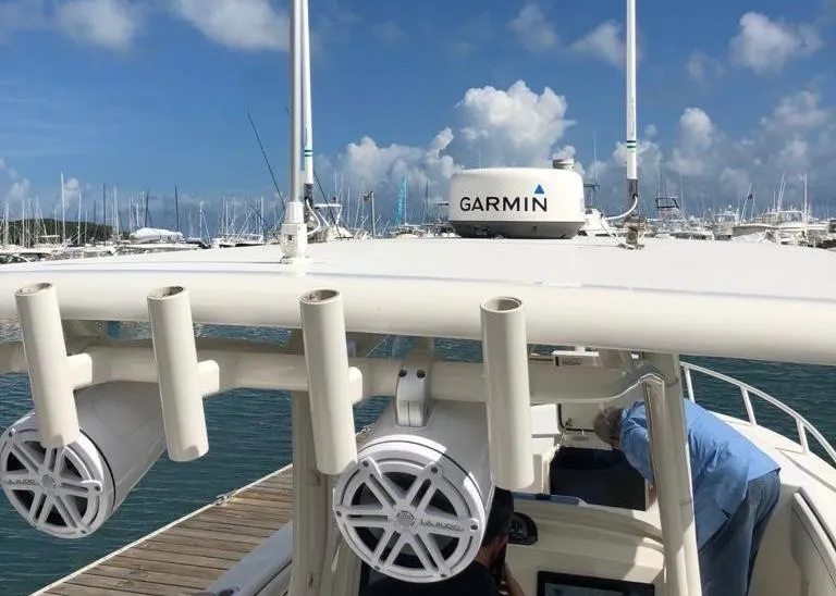 Slide: The Image of 2017 Jupiter 32 Cuddy Cabin boat docked, featuring Garmin radar and rod holders. - 10