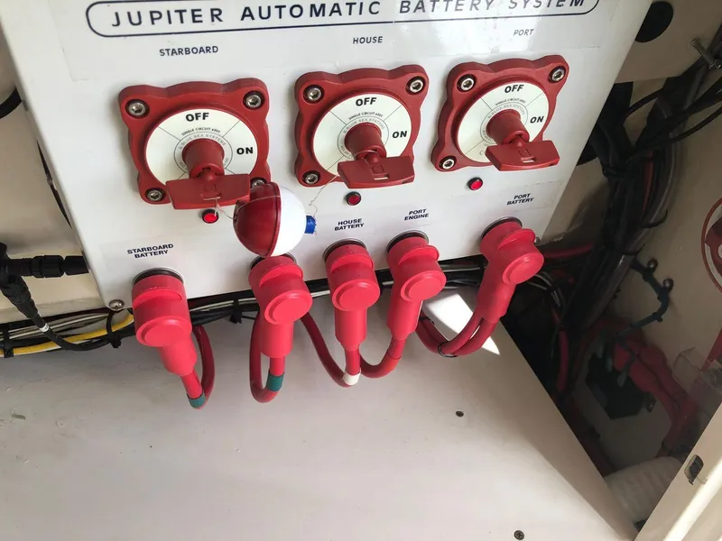 Slide: The Image of Jupiter 32 Cuddy Cabin 2017 automatic battery system with red switches and cables. - 12
