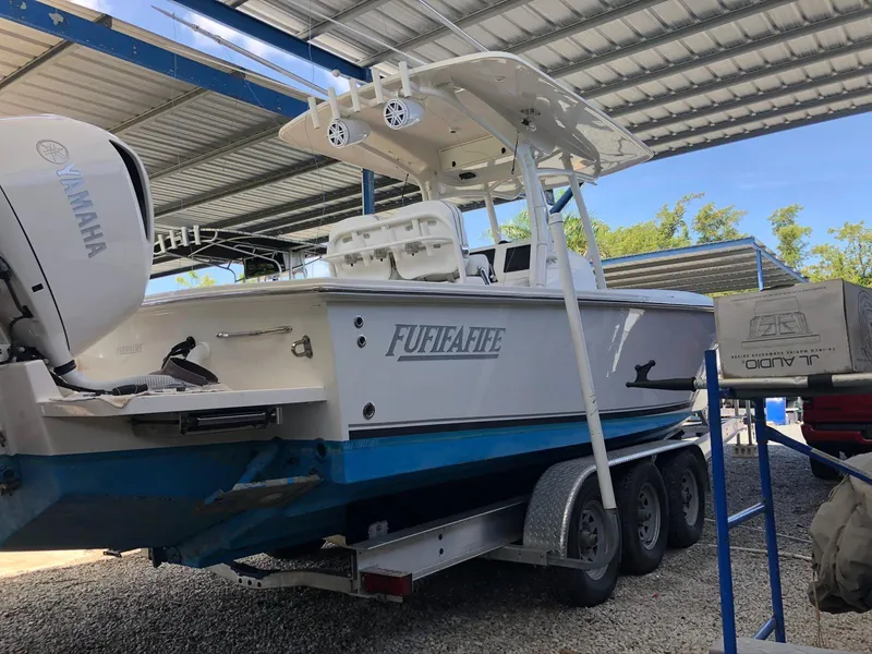 Slide: The Image of 2017 Jupiter 32 Cuddy Cabin boat on a trailer under a metal canopy. - 15