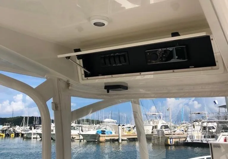 Slide: The Image of 2017 Jupiter 32 Cuddy Cabin boat interior with open electronics panel at marina. - 9