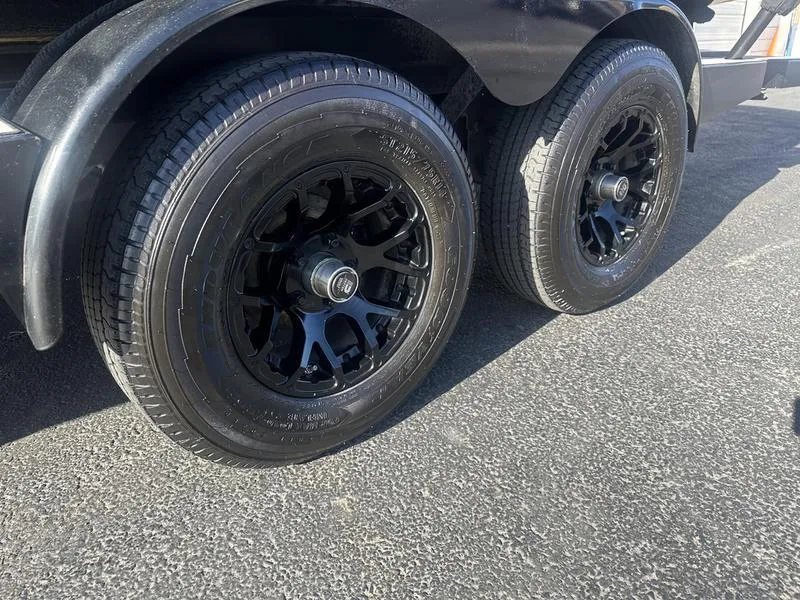 Slide: The Image of 2024 Malibu 23 MXZ trailer with black alloy wheels on asphalt. - 14