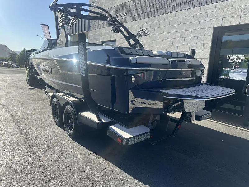 Slide: The Image of 2024 Malibu 23 MXZ boat on a trailer, parked outside a building. - 16