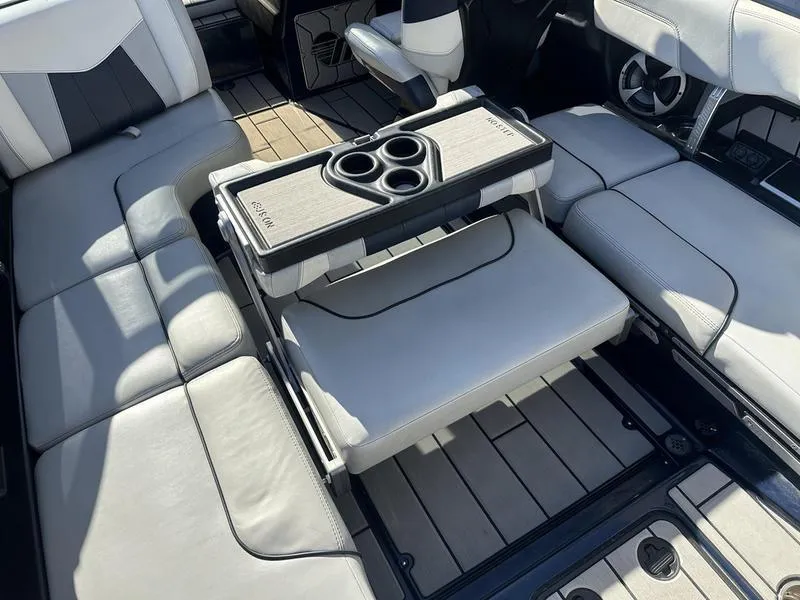 Slide: The Image of 2024 Malibu 23 MXZ boat interior with seating and cup holders. - 19