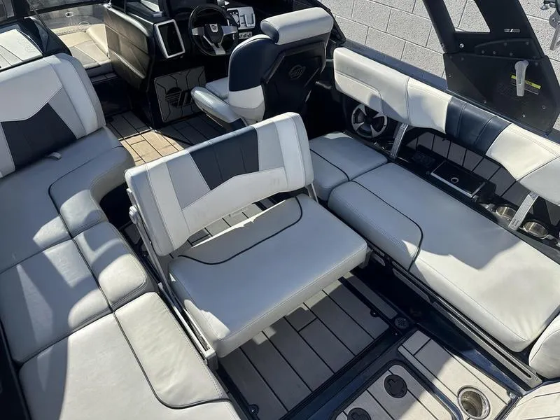 Slide: The Image of 2024 Malibu 23 MXZ boat interior with luxurious seating and modern dashboard. - 21