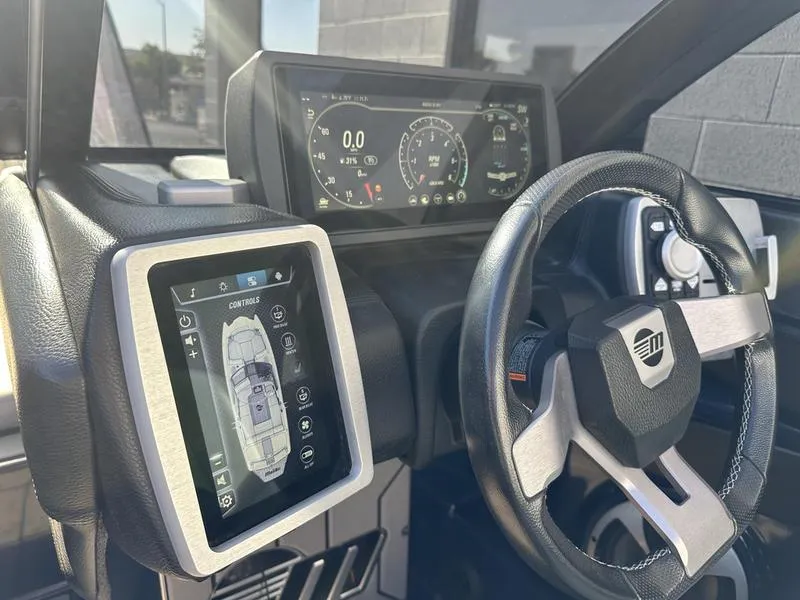 Slide: The Image of 2024 Malibu 23 MXZ dashboard with touchscreen controls and steering wheel. - 8