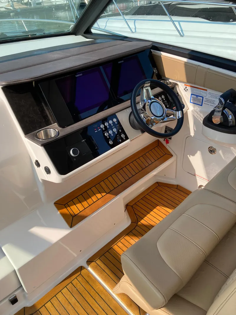 Slide: The Image of 2020 Sea Ray 320 Sundancer helm with modern controls and wood accents. - 18