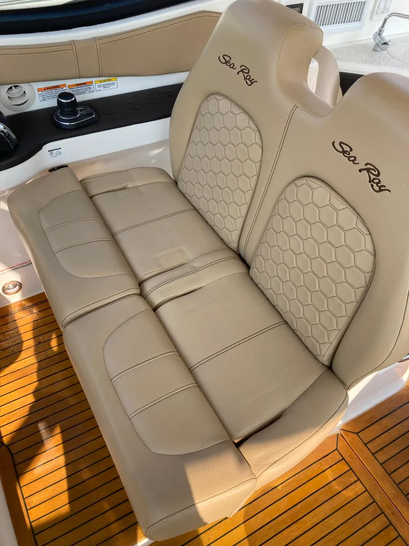 Slide: The Image of Luxurious seating on 2020 Sea Ray 320 Sundancer with tan upholstery and wood flooring. - 19