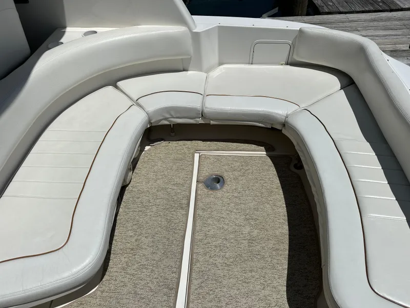 Slide: The Image of 1999 Sea Ray 310 Sundancer boat interior with white cushioned seating and carpeted floor. - 11