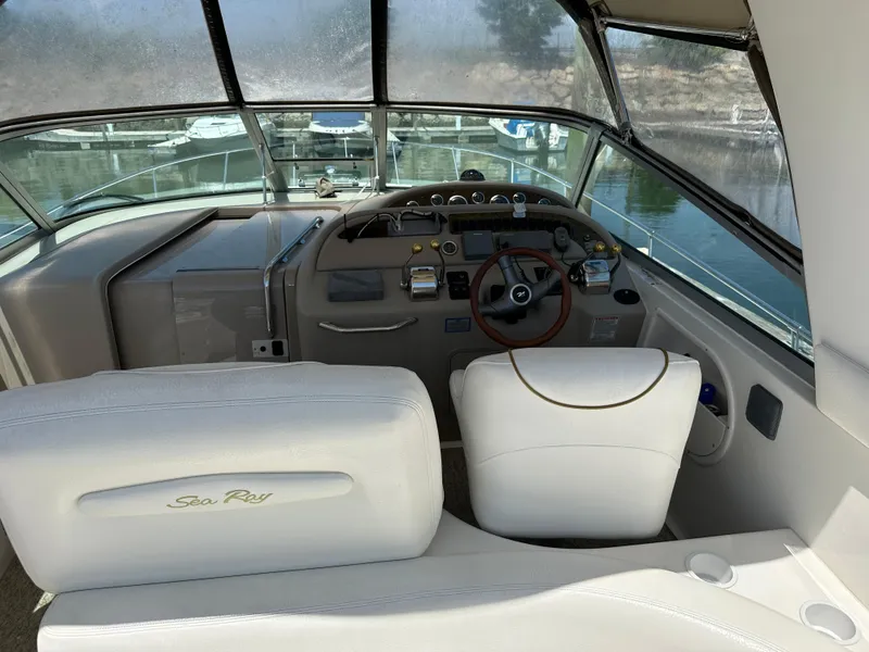 Slide: The Image of 1999 Sea Ray 310 Sundancer boat cockpit with steering wheel and dashboard controls. - 12