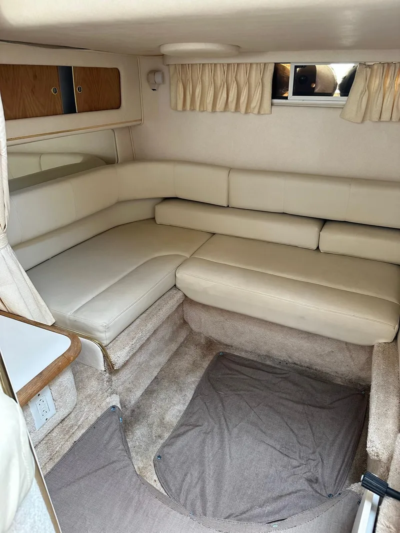 Slide: The Image of 1999 Sea Ray 310 Sundancer cabin interior with beige seating and carpet. - 15