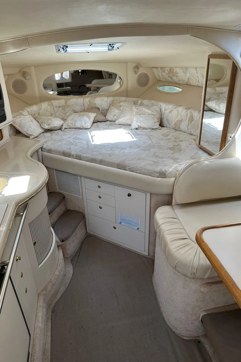 Slide: The Image of Interior of 1999 Sea Ray 310 Sundancer yacht with cozy sleeping area and elegant design. - 17