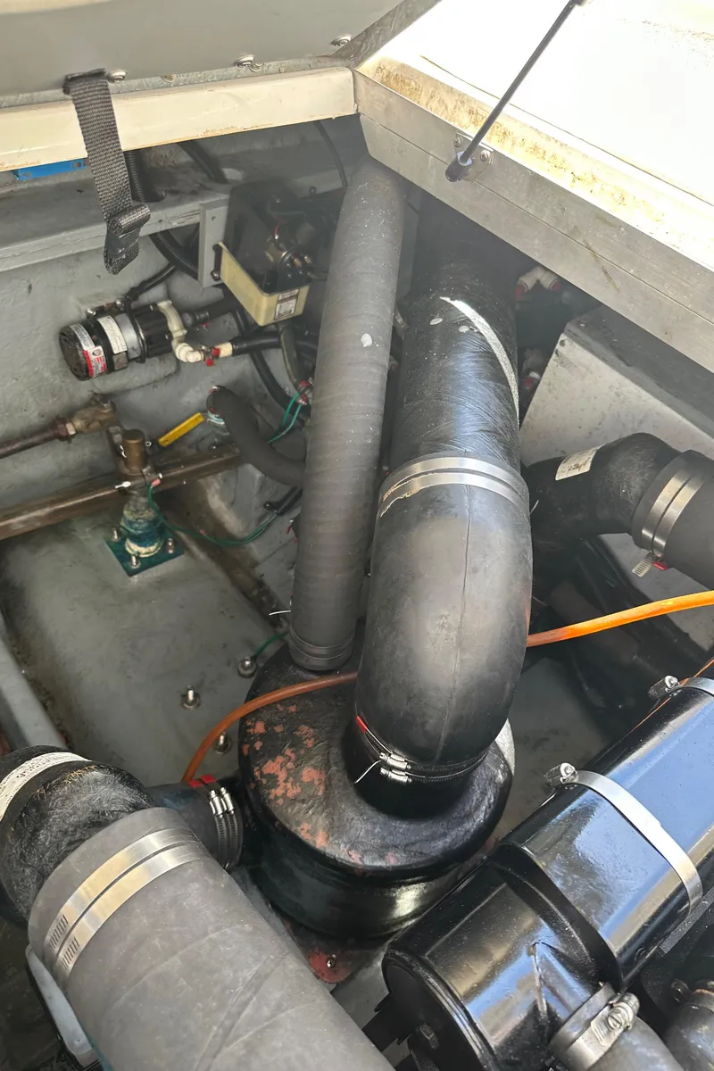 Slide: The Image of Engine compartment of a 1999 Sea Ray 310 Sundancer boat, showing hoses and components. - 26