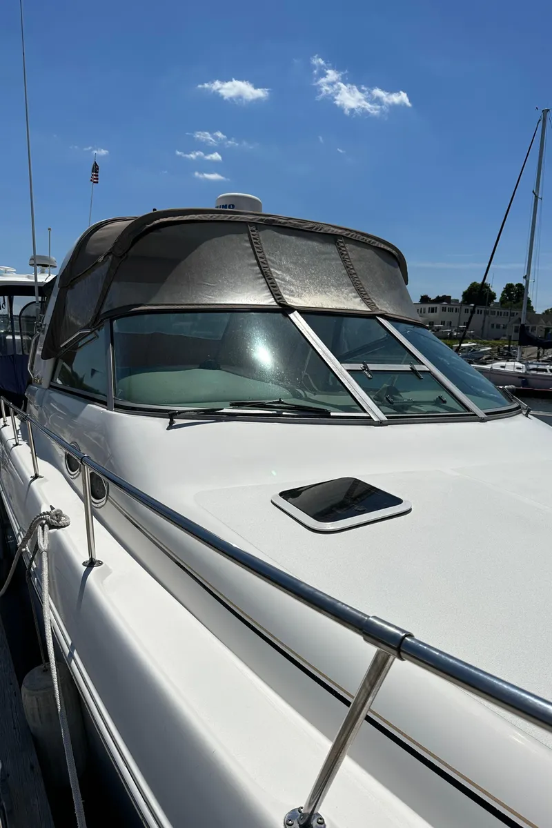 Slide: The Image of 1999 Sea Ray 310 Sundancer boat docked under clear blue sky. - 6