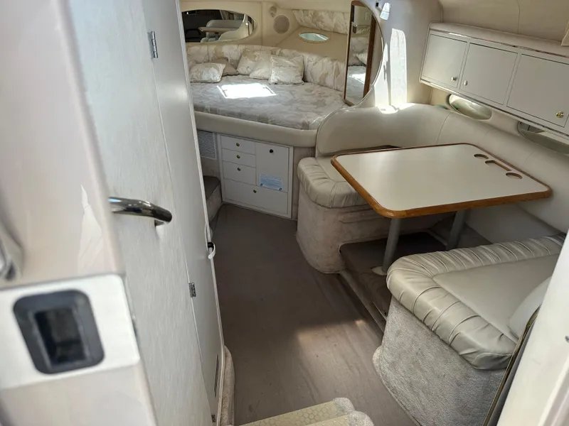 Slide: The Image of 1999 Sea Ray 310 Sundancer cabin interior with seating and sleeping area. - 14